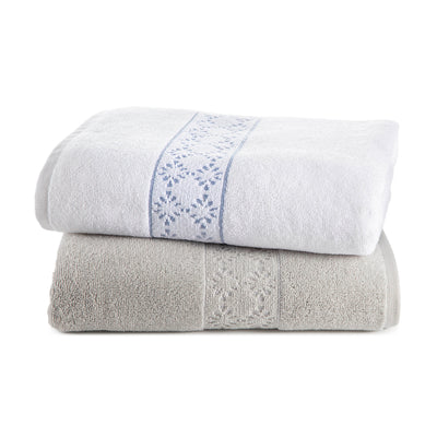 Two stacked towels, one white with blue embroidery and one gray with a textured pattern.