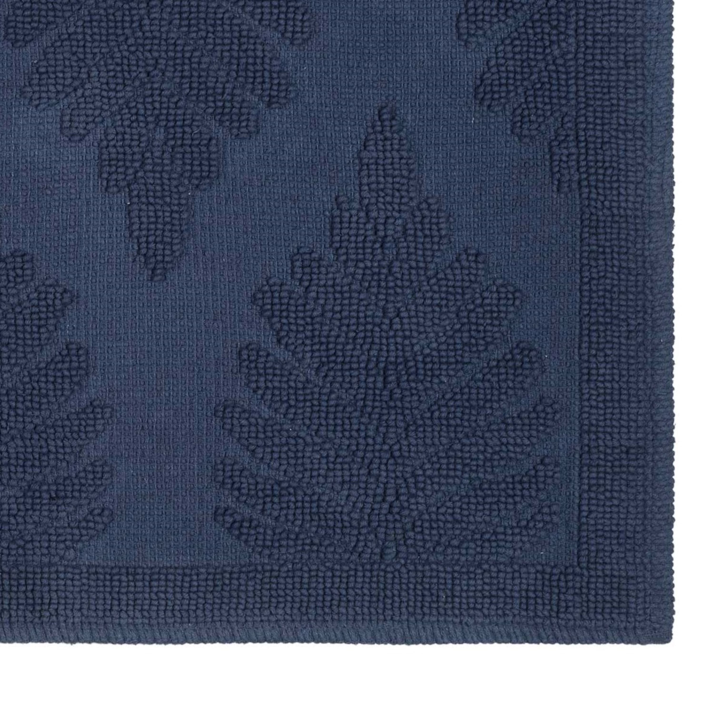 Navy bath rug featuring a textured fern pattern and a solid border.