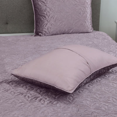 Purple quilt set on a bed.