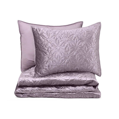 Purple textured quilt set with two pillow shams on a white background
