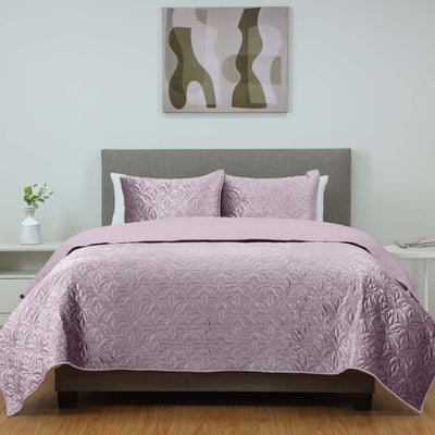 Bedroom with a bed covered in purple coverlet set.