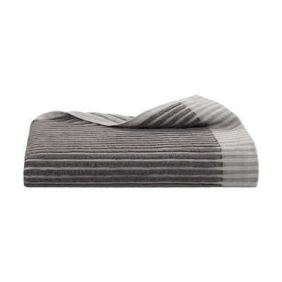 Gray towel with a sculpted stripe design, folded with one corner slightly draped over.