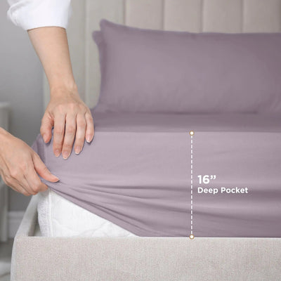 Person adjusting a fitted sheet on a bed with a 16-inch deep pocket measurement label.