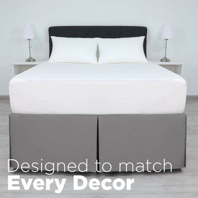 A bed dressed in white bedding, including a white mattress, white pillows, and a grey bed skirt.