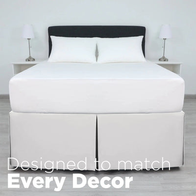 A bed dressed in white bedding, including a white mattress, white pillows, and a white bed skirt.