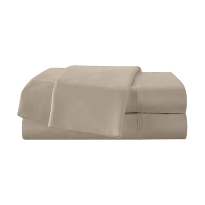 Folded beige bed sheets on a white background