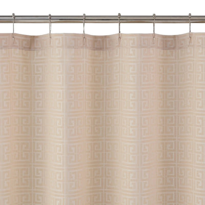 Beige shower curtain with a repeating Greek key pattern, hanging from a silver metal rod with hooks against a white background.