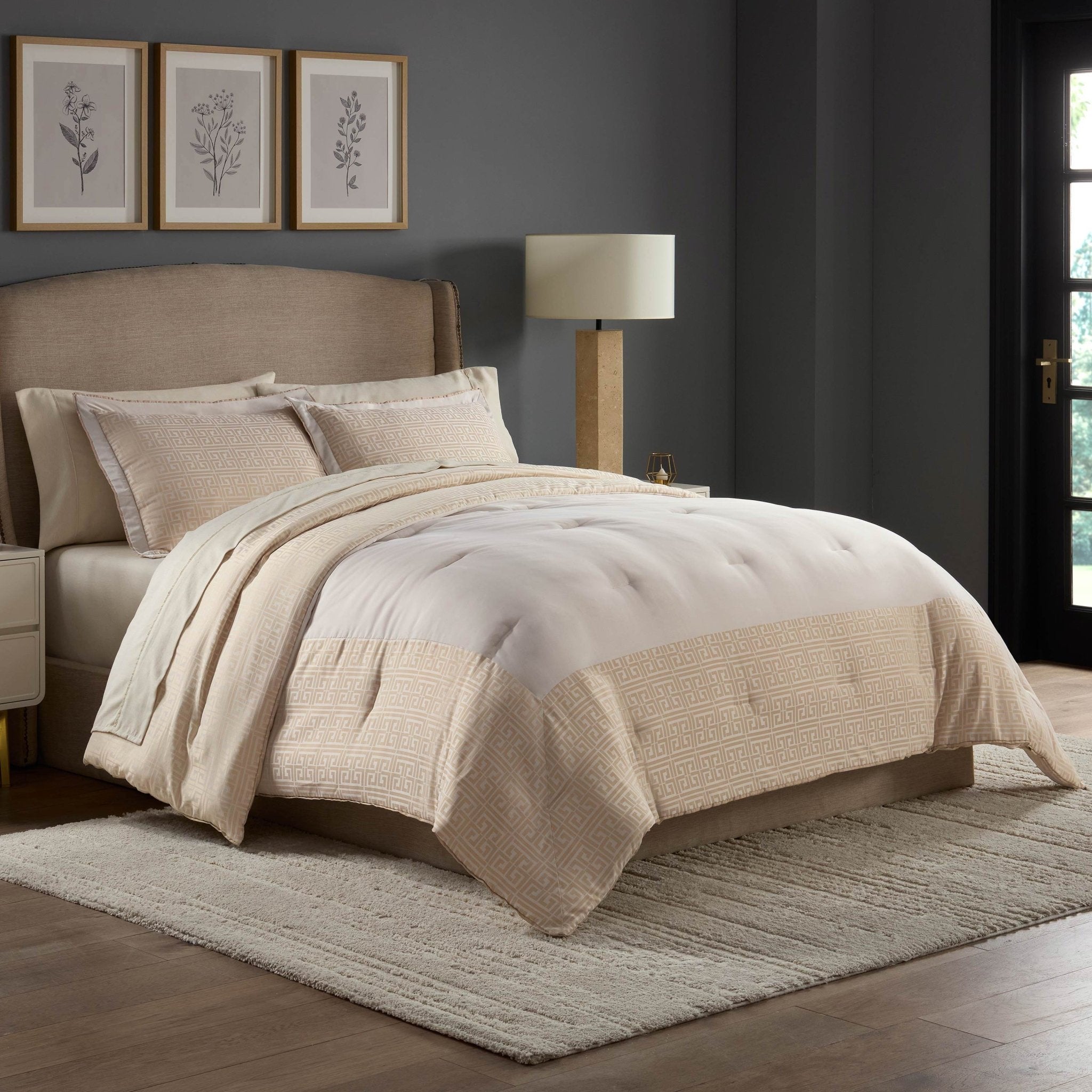 Neatly made bed with beige and white comforter set in a bedroom setting.