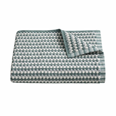 A folded textured stale bath towel featuring a woven houndstooth pattern.