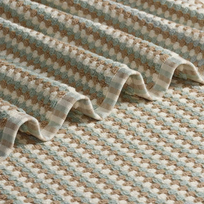 A close-up of a pebble bath towel with a repeating geometric pattern.
