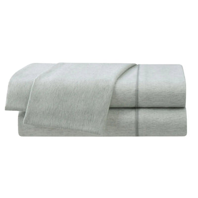 Folded light gray bed sheets on a white background