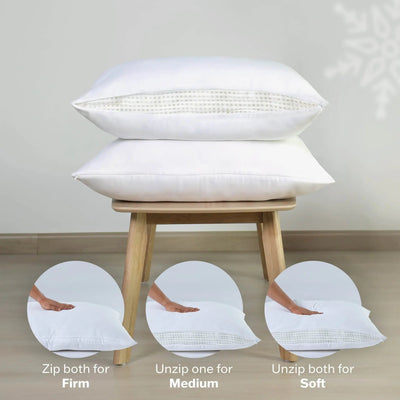 Two white pillows on a wooden stool with instructions on adjusting firmness.