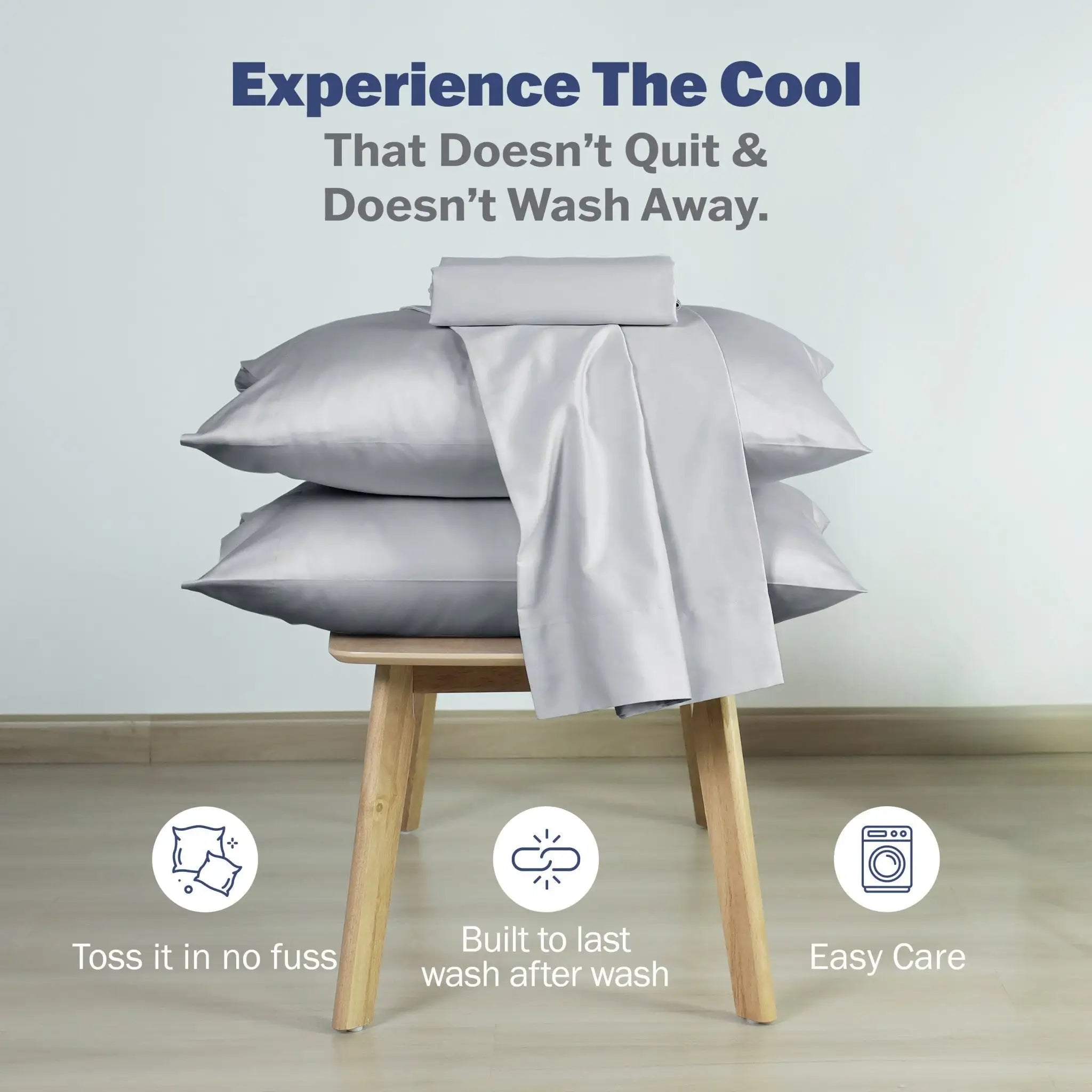 A stack of light gray pillowcases with a matching gray sheet draped over the top. Blue text at the top reads, 'Experience The Cool That Doesn't Quit & Doesn't Wash Away.
