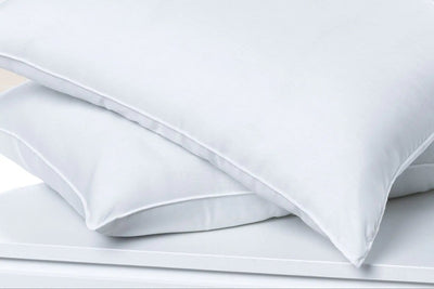 Stack of white pillows on a light gray background