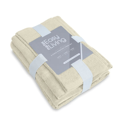 A folded set of six ivory towels wrapped in a clear plastic sleeve with a gray paper label that reads 'The Easy Living 6-Piece Everyday Essentials Set'.