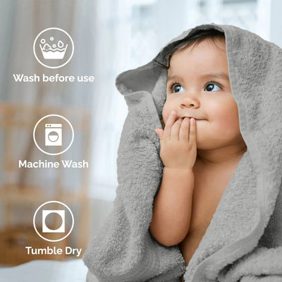 Child wrapped in a gray towel with washing instructions displayed.