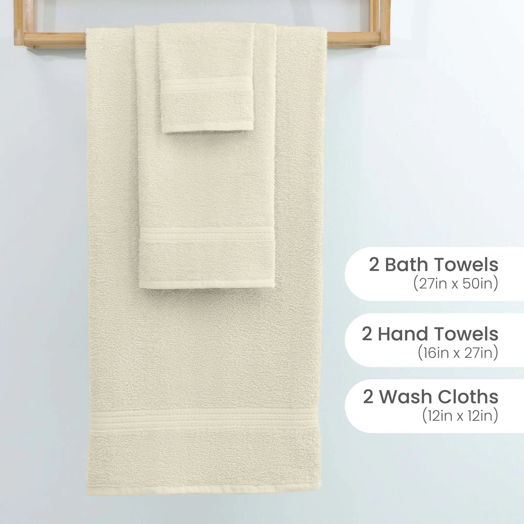 A set of three ivory towels hanging on a wooden rack against a light wall, with text labels on the right specifying sizes: 2 Bath Towels (27in x 50in), 2 Hand Towels (16in x 27in), and 2 Wash Cloths (12in x 12in).