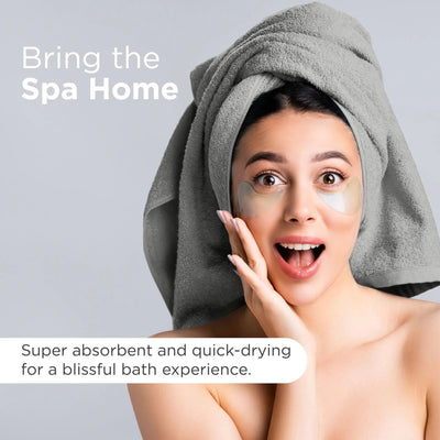 A woman with a gray towel wrapped around her head and under-eye patches on her face, with text reading 'Bring the Spa Home' and 'Super absorbent and quick-drying for a blissful bath experience.' on a light gray background.