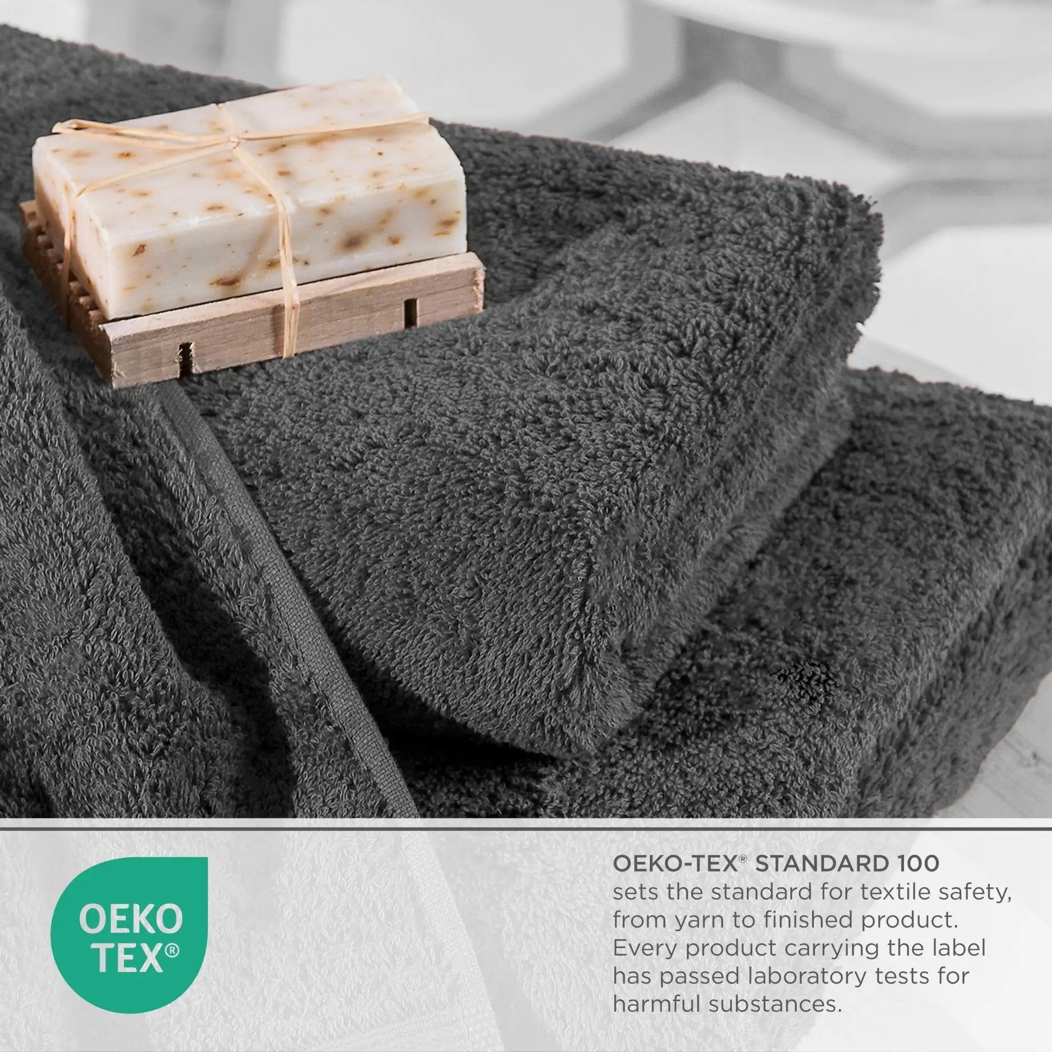 Charcoal towels with a wooden soap dish holding two bars of soap on a light gray background, featuring the OEKO-TEX logo.