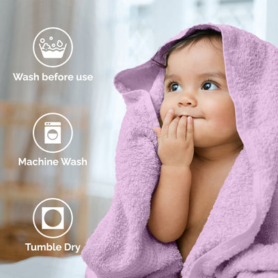 Child wrapped in a lilac towel with washing instructions displayed.