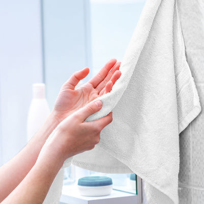 Person holding a white towel with a blurred background