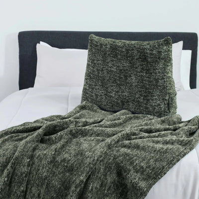 Green textured blanket and pillow on a bed with white pillows and headboard.