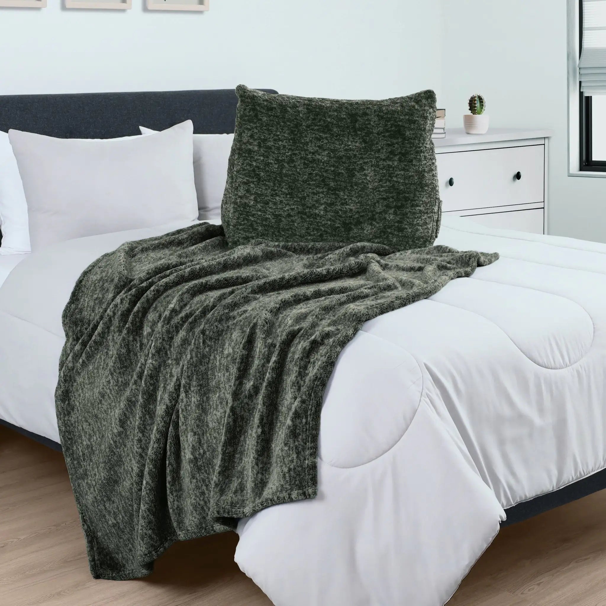 Green pillow over a bed with white bedding in a bedroom setting.
