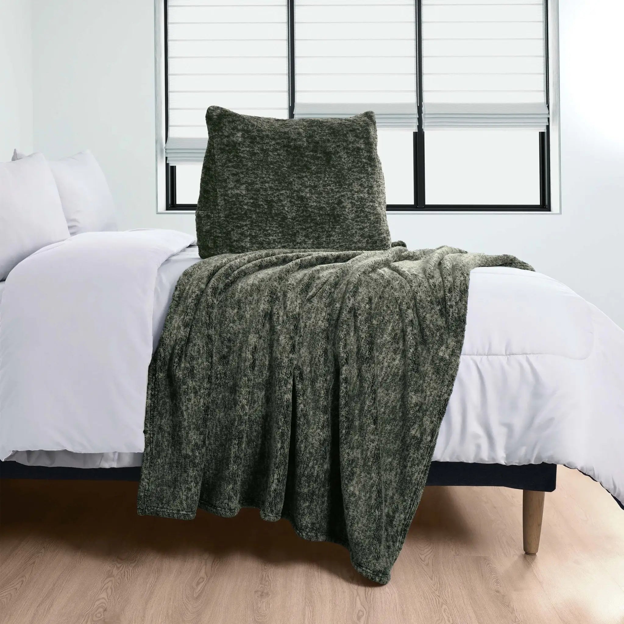Green Pillow over a bed with white bedding in a room.