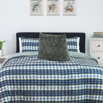Bed with plaid comforter and pillows.