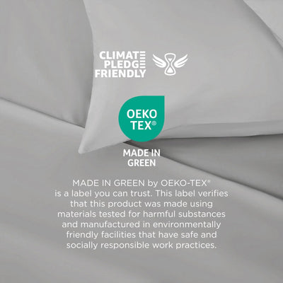 Gray pillow with Climate Pledge Friendly and OEKO-TEX branding on a gray background