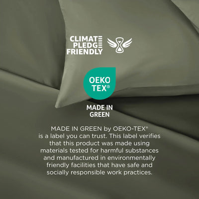 A close-up of olive green fabric with printed certification logos and text, including Climate Pledge Friendly, OEKO-TEX, and Made in Green, plus a small white feather icon.
