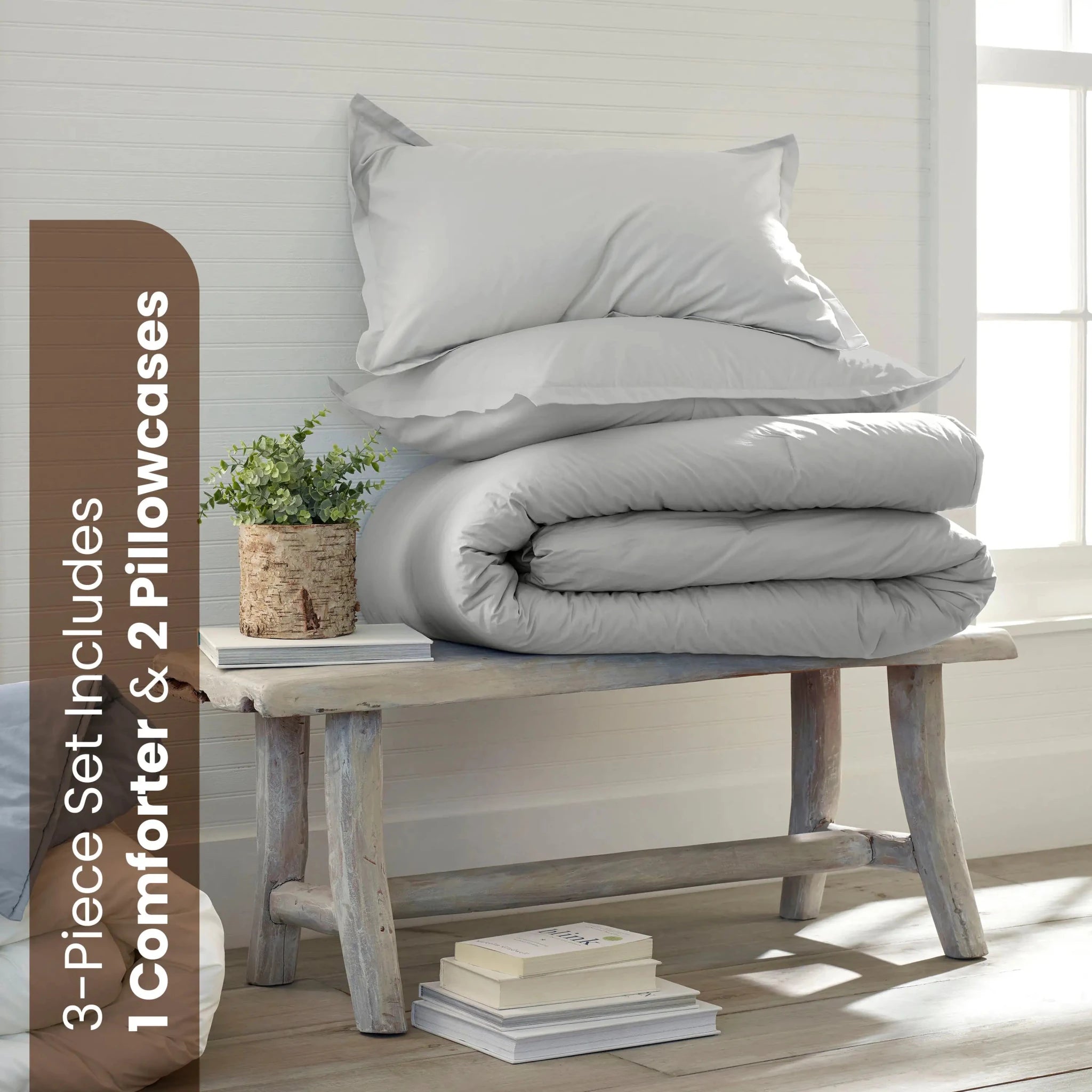 A light gray bedding set consisting of a comforter and two pillowcases. A brown text banner on the left reads '3-Piece Set Includes 1 Comforter & 2 Pillowcases'.