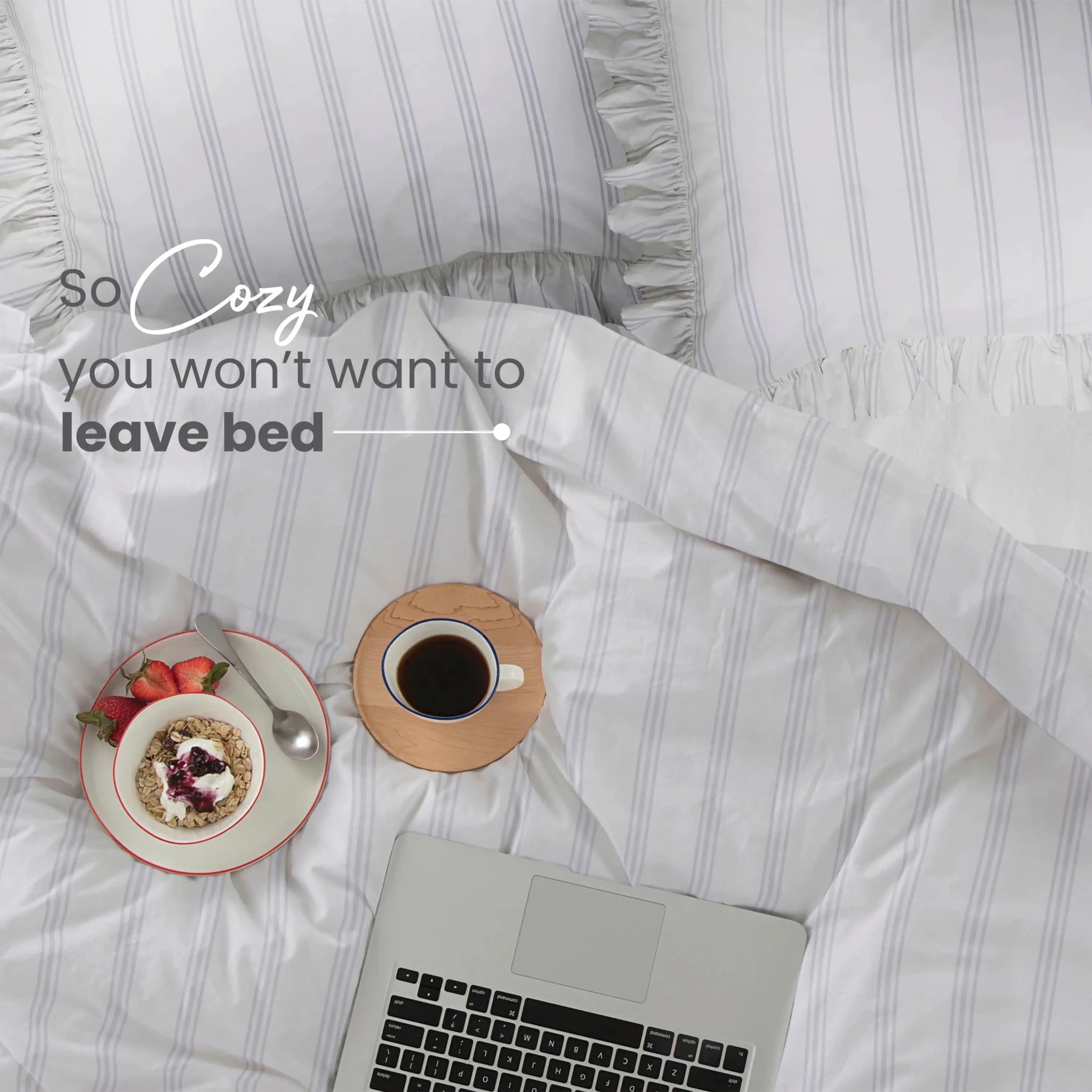 Cozy bedroom scene with laptop, coffee, and dessert on striped bedding.