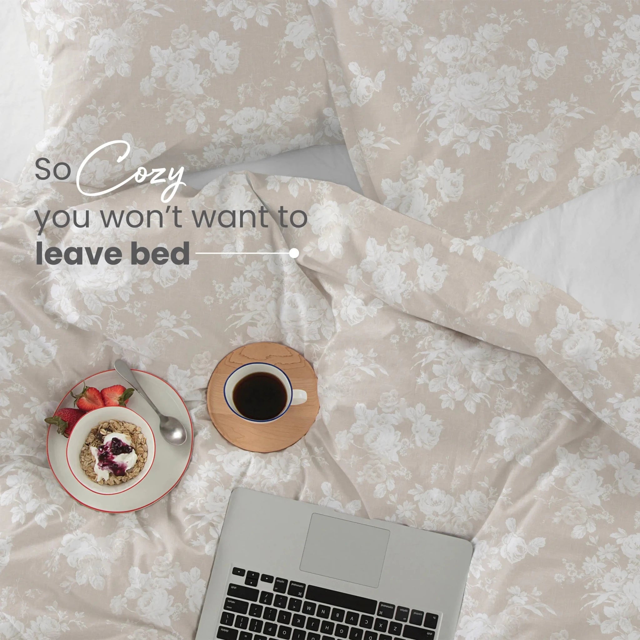 Floral-patterned bed with a laptop, coffee, and plate of food on a light background.