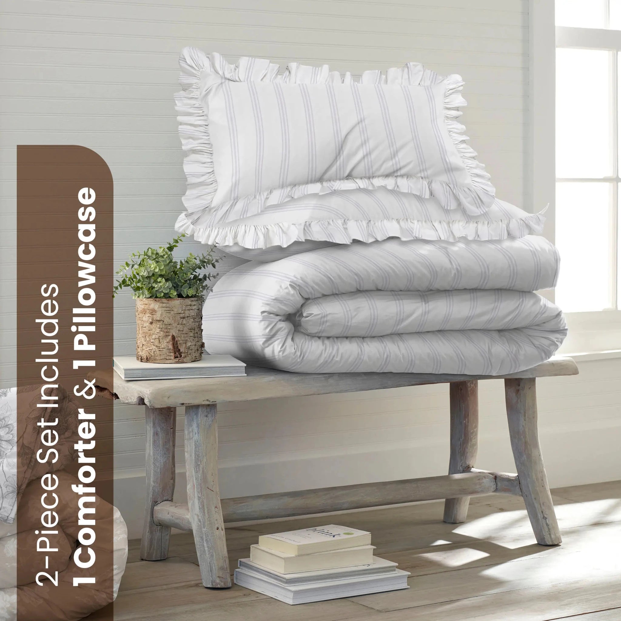 A striped comforter bedding set consisting of a comforter and two pillowcases, neatly stacked on a rustic wooden bench in a bright, sunlit room. A brown vertical banner on the left reads '2-Piece Set Includes 1 Comforter & 1 Pillowcases'.