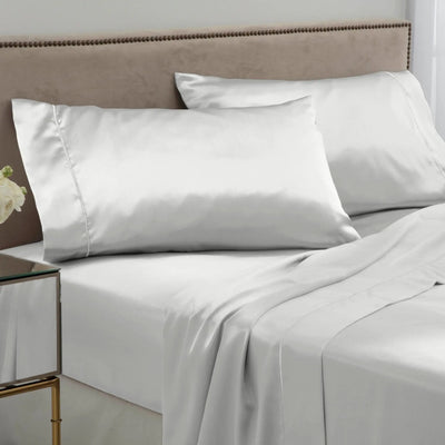 White satin sheet and pillowcase set on a bed.