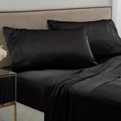 Black bed sheets and pillows on a neatly made bed.