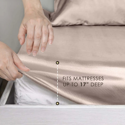 Close-up of a person's hands lifting a fitted sheet off a mattress to demonstrate fit, with text reading 'FITS MATTRESSES UP TO 17" DEEP'. The sheet is a warm taupe/champagne color and the mattress is white.