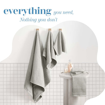 Gray towels hanging on a rack with a minimalistic bathroom setting.