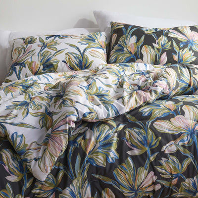 Floral comforter set on a bed with a white wall background