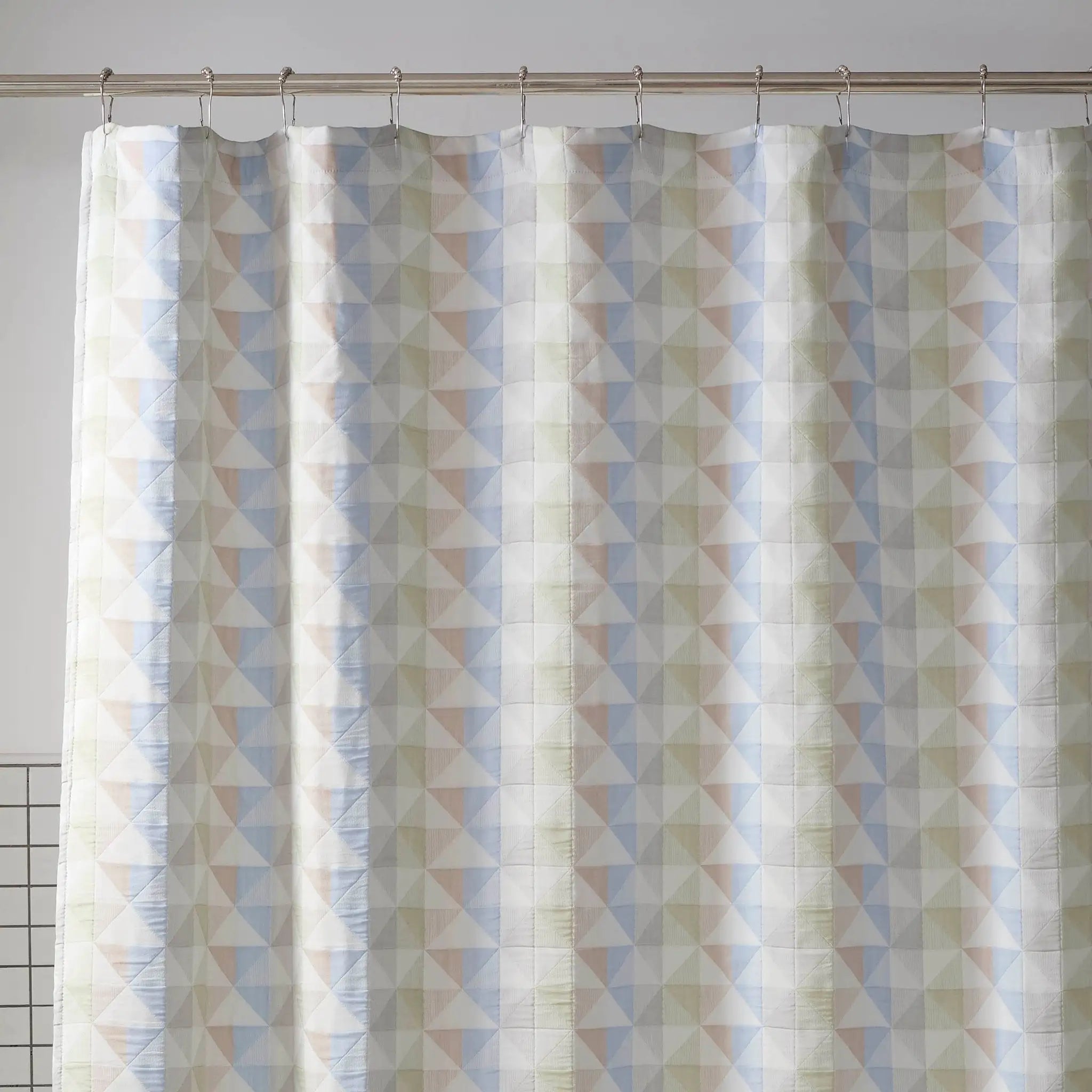 Shower curtain with geometric triangle pattern on a plain background