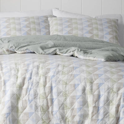 Comforter with geometric pattern on a bed.