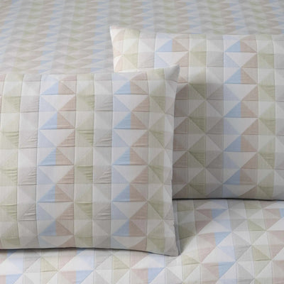 Geometric patterned comforter and pillow sham on a matching fabric background