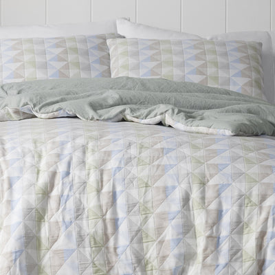 Quilted comforter set with geometric pattern on a bed.