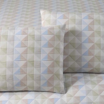 Geometric patterned pillow shams on a matching fabric background