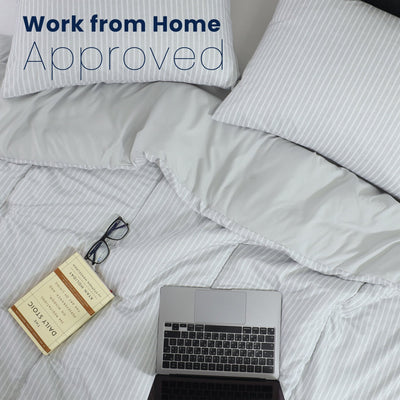 Laptop on a comforter with 'Work from Home Approved' text above