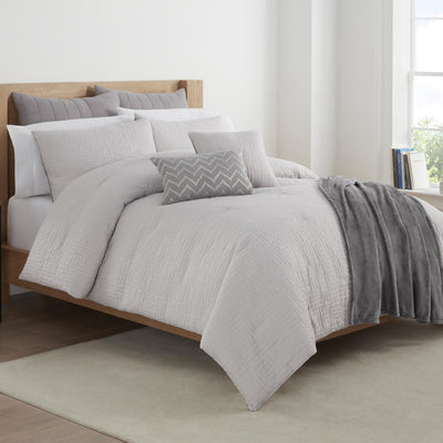 Gray bedding set on a bed in a bedroom.