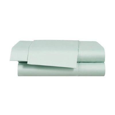 Two light green folded bed sheets on a white background