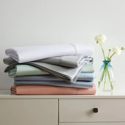 Stack of folded bed sheets in various colors.