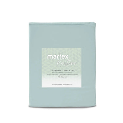 A folded light blue sheet set in a soft dust bag with a white label reading 'martex Restore' on a clean white background.